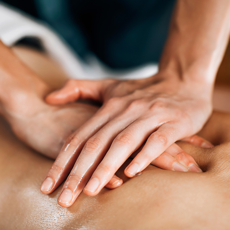 Hände, die übereinander gelegt sanften Druck bei einer ayurvedischen Massage ausüben.