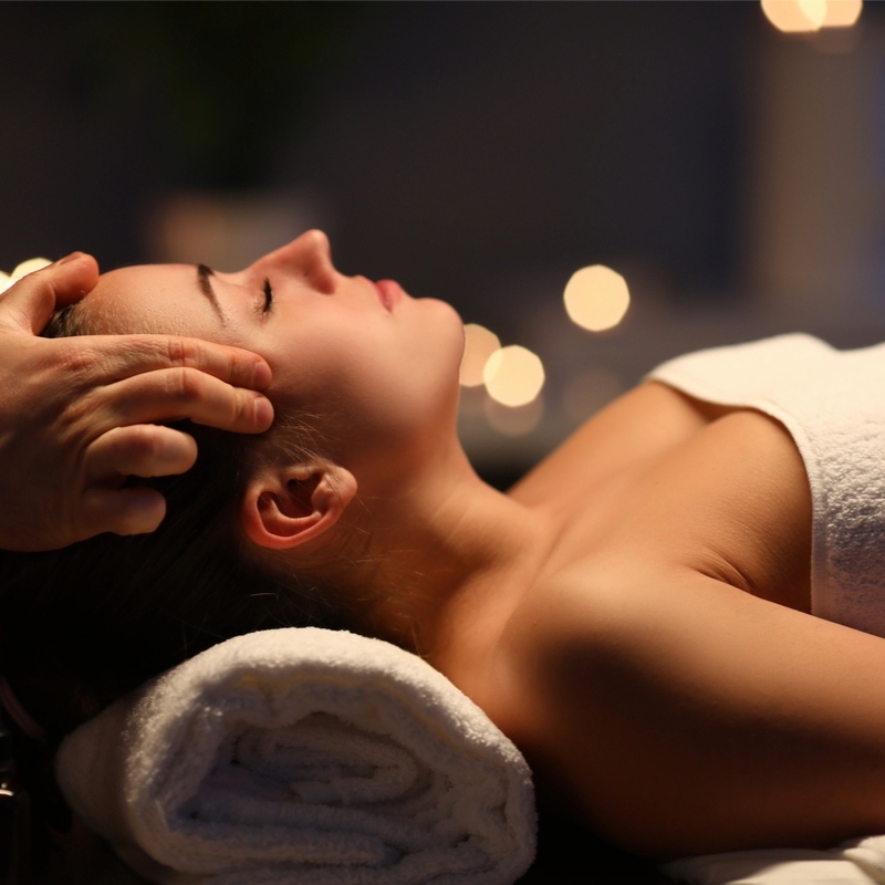 Nahaufnahme einer Frau, die eine entspannende ayurvedische Kopfmassage erhält.