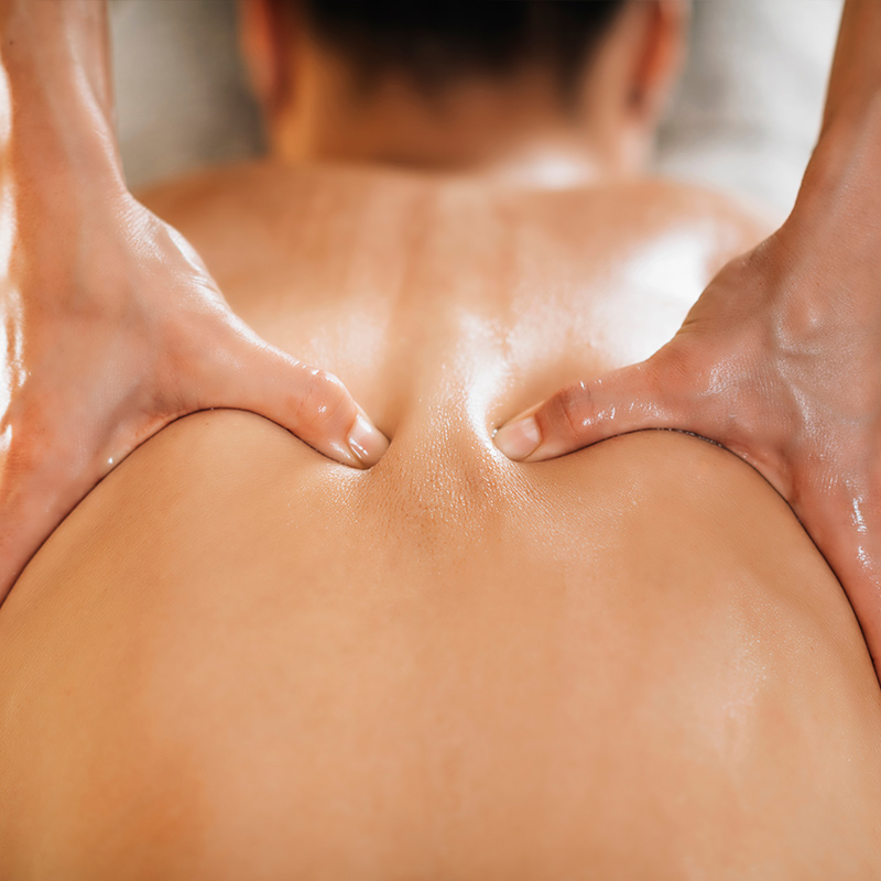 Ayurvedische Rückenmassage mit warmem Öl zur Lockerung von Verspannungen und zur Förderung der Durchblutung.