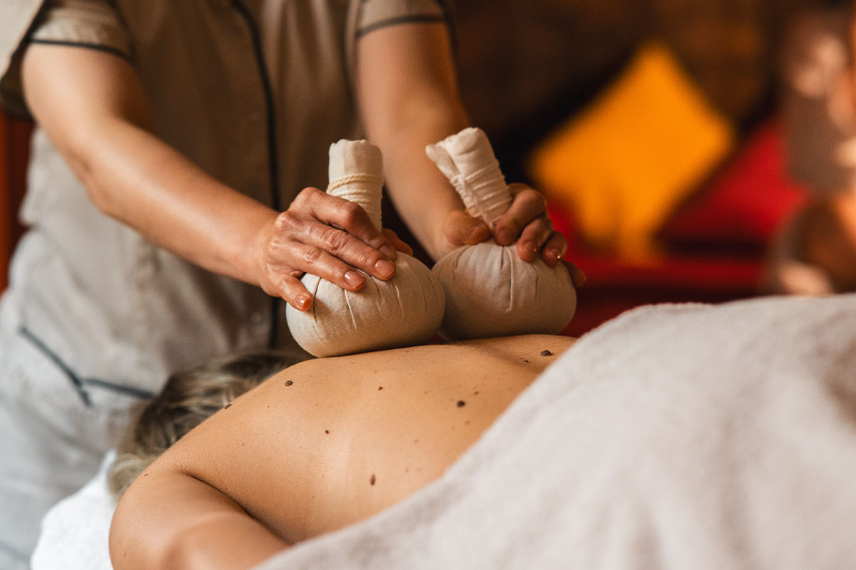 Frau bei einer ayurvedischen Kräuterstempel-Massage im Wellnessurlaub im Grand Hotel Binz mit vielen Ayurveda Angeboten.