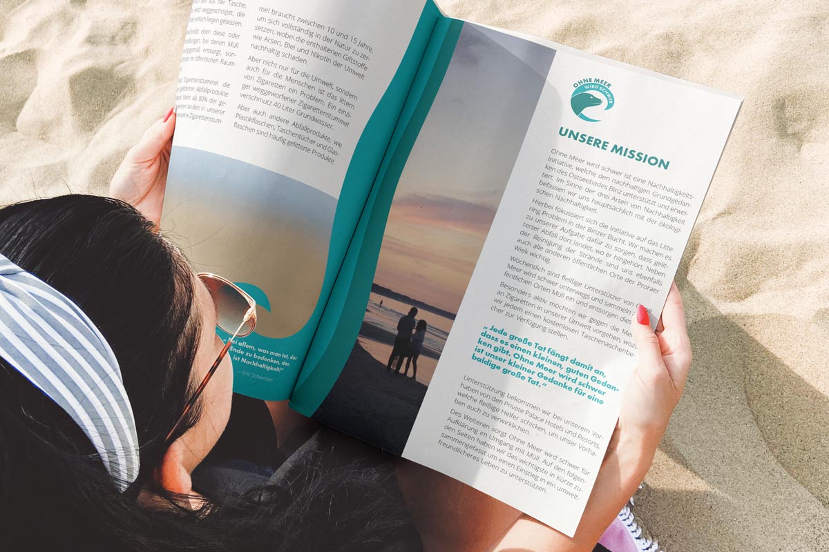 Woman on the beach with OMWS magazine – Grand Hotel Binz is part of the sustainability initiative "Ohne Meer wird schwer"